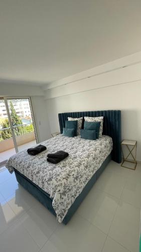 une chambre avec un grand lit avec des oreillers dessus dans l'établissement Cannes Pointe Croisette : superbe logement vue mer, à Cannes