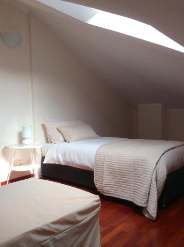 two beds in a room with a roof at Apartment La Mansarda in Alba