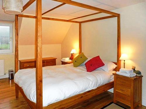 a bedroom with a wooden canopy bed with two pillows at Hillview House Hostel Inverness in Inverness