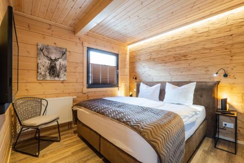 A bed or beds in a room at Bergwaldchalets Wellness