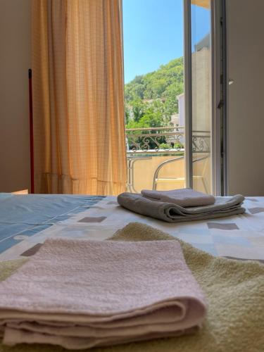 a bedroom with two towels on a bed with a window at Apartments Manojlovic in Budva