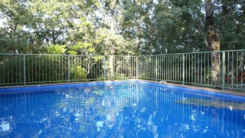 a swimming pool in front of a fence at Casa Rural: La Casa Mágica de Gredos in Madrigal de la Vera