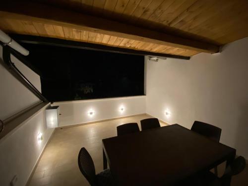 a dining room with a table and chairs and a large window at Koralline accommodation in Tropea
