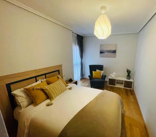 1 dormitorio con 1 cama grande y 1 silla en Casa Río Duero, en Soria