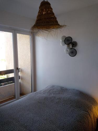 1 dormitorio con cama y ventana en Le petit Cabourgeais, en Cabourg