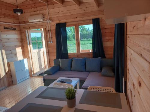 a living room with a couch in a log cabin at Domki nad stawem in Sambród