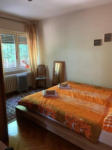 1 dormitorio con 1 cama, 1 silla y 1 ventana en Apartment Sarajevo Hills, en Sarajevo