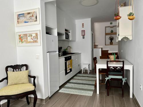 a kitchen with a table and a dining room at A Casa Branca in Mértola