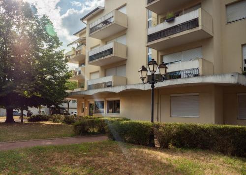 un immeuble d'appartements avec un éclairage de rue en face de celui-ci dans l'établissement L'élégant de fourvière, à Lyon