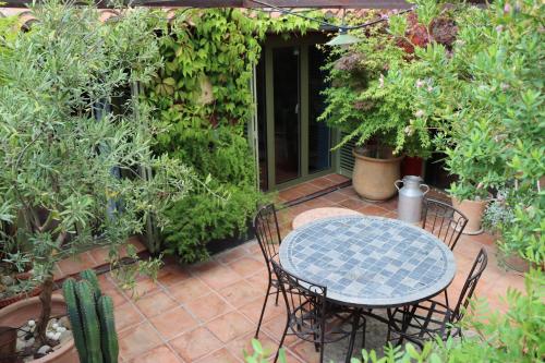 un tavolo e sedie su un patio con piante di Grand loft de charme, place du village à Thuir a Thuir