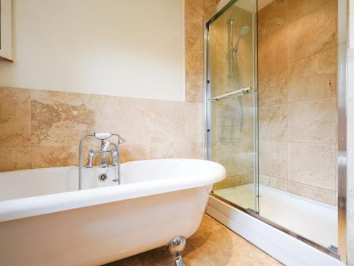 ein Badezimmer mit Badewanne und Glasdusche in der Unterkunft Cloudberry Cottage in Stanton in Peak