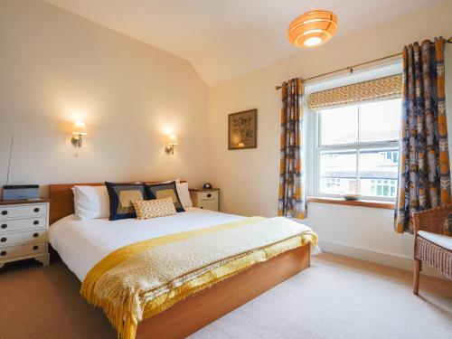 ein Schlafzimmer mit großem Bett und Fenster in der Unterkunft Cloudberry Cottage in Stanton in Peak