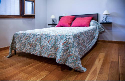 a bedroom with a bed with a red pillow at Apartamento Rústico en Ojén in Ojén