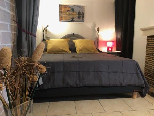 a bedroom with a large bed with yellow pillows at les Quatre Vents in Bragny-sur-Saône