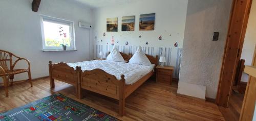 - une chambre avec un lit doté de draps blancs et une fenêtre dans l'établissement Fewo am Saalerbodden, à Bartelshagen
