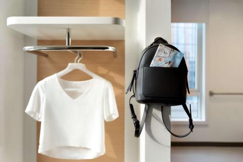 a bag and a white t shirt on a hanger at YOTEL London City in London