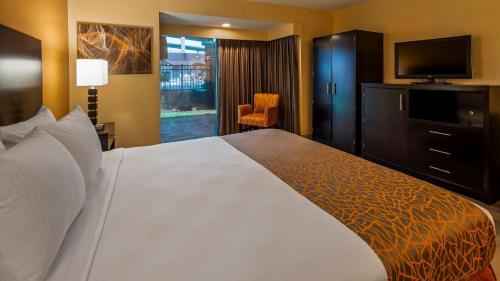 a hotel room with a large bed and a flat screen tv at Best Western The Plaza Hotel Honolulu Airport - Free Breakfast in Honolulu