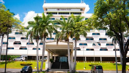 un edificio blanco con palmeras delante en Crowne Plaza Managua, an IHG Hotel en Managua