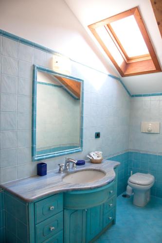 a bathroom with a sink and a mirror and a toilet at The Sweet Garret in Agerola