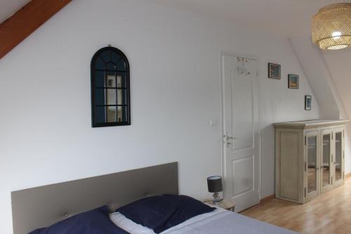 une chambre avec un lit et une horloge au mur dans l'établissement Les GOELETTES, à Bricqueville-sur-Mer