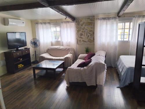 a living room with two beds and a tv at Moderno Loft en Urb La Marina in San Fulgencio