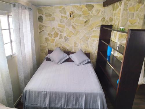 a bedroom with a bed and a stone wall at Moderno Loft en Urb La Marina in San Fulgencio