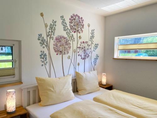 a bedroom with two beds with flowers on the wall at Hofgut Bisdamitz - Ferienhaus "Knoff" in Bisdamitz