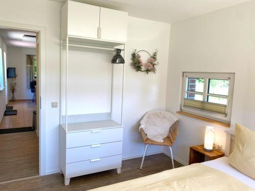 a bedroom with a bed and a dresser and a chair at Hofgut Bisdamitz - Ferienhaus "Knoff" in Bisdamitz