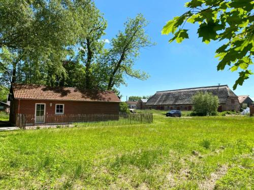 an old house and a barn in a field at Hofgut Bisdamitz - Ferienhaus "Knoff" in Bisdamitz