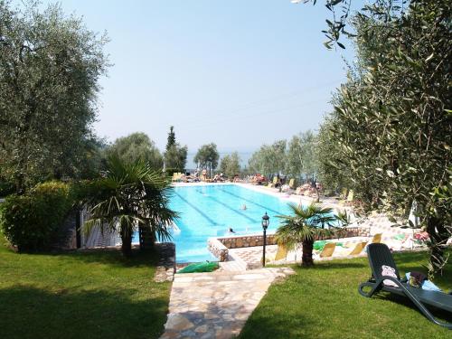 a large swimming pool with people in a resort at Taki Village in Brenzone sul Garda