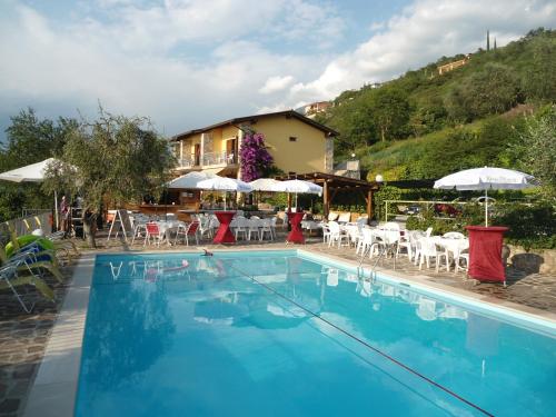 a large swimming pool with chairs and umbrellas at Taki Village in Brenzone sul Garda