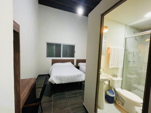 uma casa de banho com uma cama, um chuveiro e um lavatório. em La Casona Real em Durango