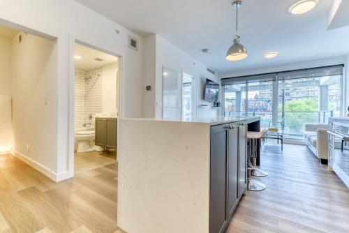 an open kitchen with a large island and a living room at Kensington Suite 2bed & 1bath in Calgary