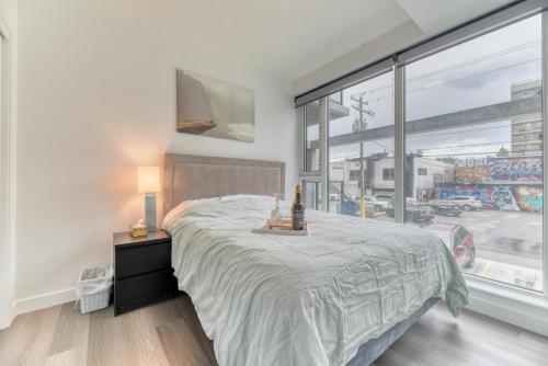 1 dormitorio con cama y ventana grande en Kensington Suite 2bed & 1bath en Calgary