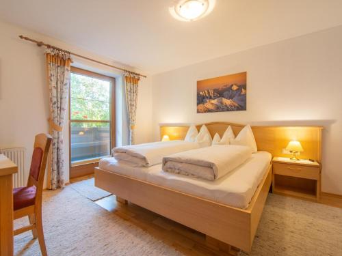 a bedroom with two beds and a large window at Schleicherhof V in Strass im Zillertal