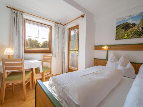 a hotel room with a bed and a table and chairs at Schleicherhof II in Strass im Zillertal