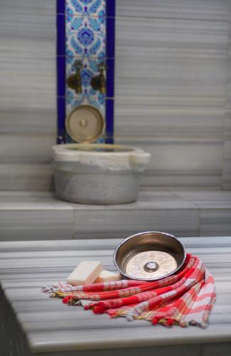 a table with a plate of food on a red scarf at Pera Tulip Hotel & Spa - Istanbul Taksim Pera City Center in Istanbul