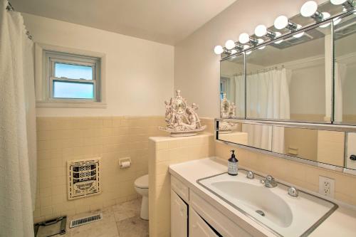 Un baño con lavabo, espejo e inodoro. en Hot Tub and Yard Spacious Hot Springs Home!, en Hot Springs