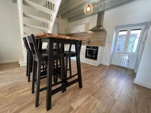 une cuisine avec une table et des chaises dans une pièce dans l'établissement Maison idéalement située avec parking gratuit, à Ancenis