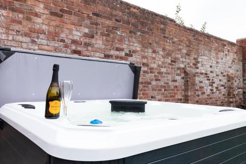 una bottiglia di vino seduta su una vasca da bagno di The Olde Coach House a Chesterfield