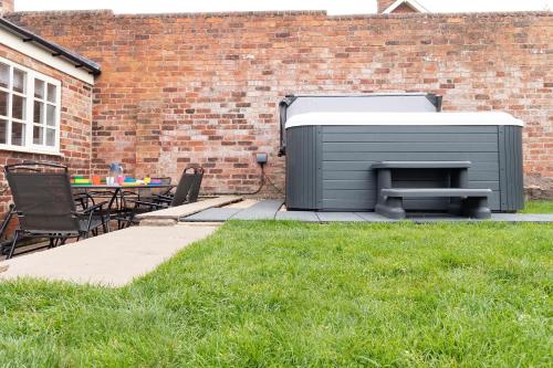 a barbecue grill in a yard next to a brick building at The Olde Coach House in Chesterfield