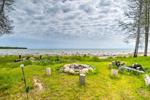 a field of grass with a body of water at Secluded Lake Michigan Home Private Fire Pit in Manistique