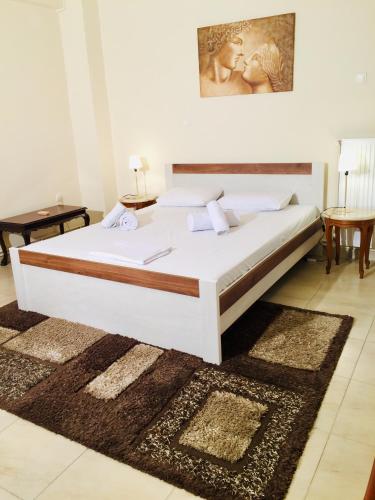 - une chambre avec un grand lit blanc et un tapis dans l'établissement LuckyGeorge IsimeriaHomz, à Thessalonique