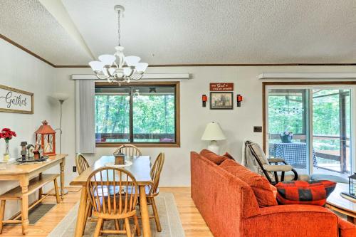 a living room with a couch and a table at Quaint Murphy Cabin in Serene Wooded Setting! in Murphy