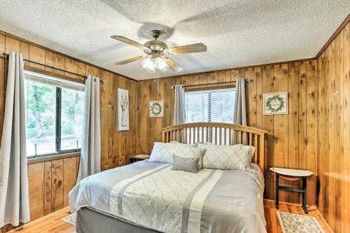 Un dormitorio con una cama y un ventilador de techo. en Quaint Murphy Cabin in Serene Wooded Setting!, en Murphy