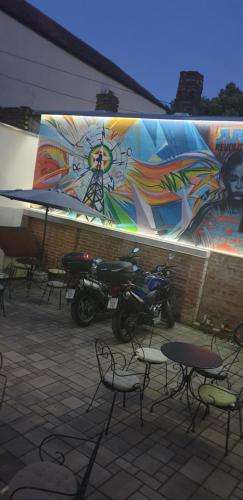 a mural on the side of a building with chairs and a motorcycle at SMART in Niš