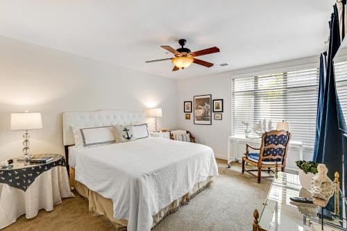 una camera da letto con un letto e un ventilatore a soffitto di Seacliff Retreat Gorgeous third-floor condo with pool, hot tub, & fitness room - walk to beaches a Oceanside
