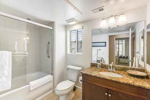 un bagno con un lavandino e una doccia di Seacliff Retreat Gorgeous third-floor condo with pool, hot tub, & fitness room - walk to beaches a Oceanside