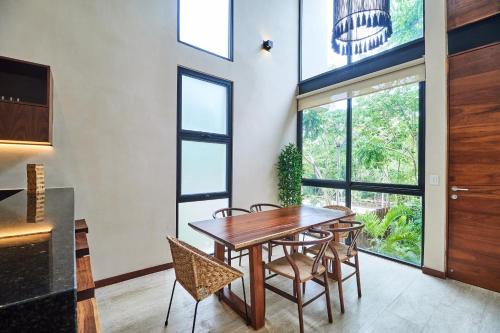 a dining room with a wooden table and chairs at Private pool and rooftop in Aldea Zama, 24 7 security in a gated community 15 in Tulum