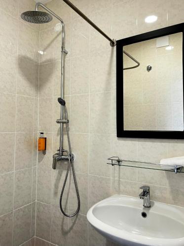 a bathroom with a shower with a sink and a mirror at VILA ALEGRIA by brugrani in Funchal